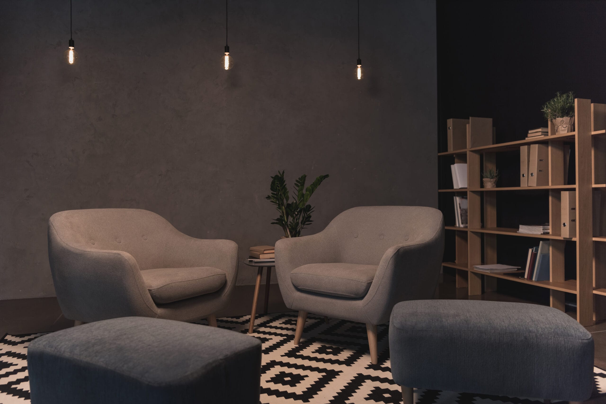 modern loft style interior with armchairs and shelves with books